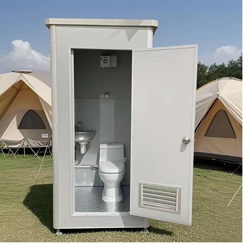 Portable restrooms lit by string lights at an evening event