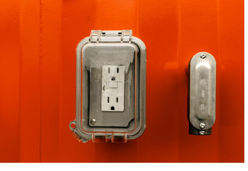 Weatherproof electrical outlet and junction box hardware on a restroom trailer